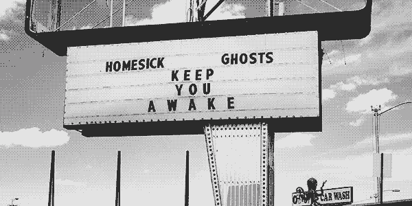 old roadside marquee sign in the desert with the words 'homesick ghosts keep you awake'